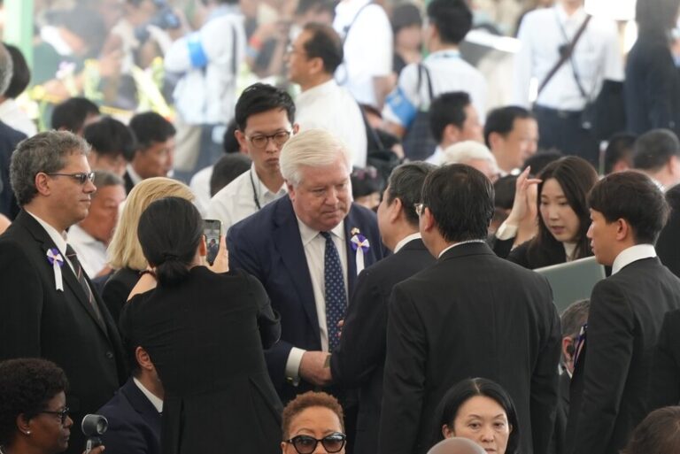 米国のジョージ・グラス駐日大使（白髪の男性）と握手を交わす李逸洋駐日代表