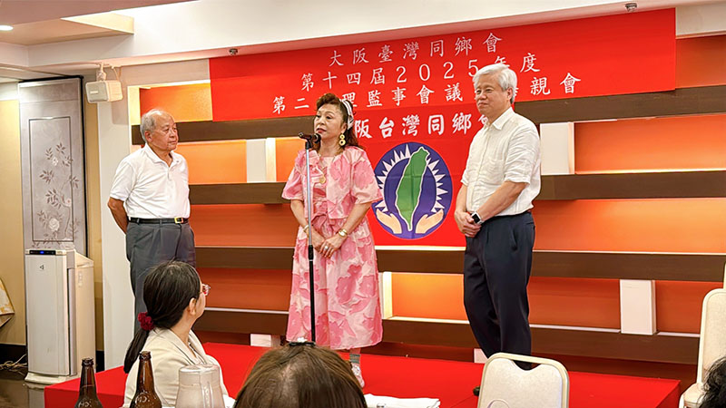 懇親會上，洪里勝信顧問以大阪中華學校新任理事長身分，向大家介紹遷校計畫與未來展望，並感謝本會在關鍵時刻伸出援手。本會石井豐理事亦上台補充說明，表示未來該校將加強與台灣大學院校合作，提供學生更多返台升學的可能性。

駐大阪辦事處僑務組黃麗婷課長亦親臨會場，致詞中高度肯定本會在文化推廣與僑務參與上的努力，並感謝謝美香會長日前代表出席「We Taiwan台灣文化in大阪」開幕活動，展現台灣在國際文化舞台上的自信與創意。黃課長也呼籲現場鄉親持續支持本系列展演活動，一同為台灣加油、讓世界看見台灣的文化能量。

會議結束後，理監事們與會員一同合影並共進晚餐，交流熱絡、情誼深厚。謝美香會長表示，未來同鄉會將繼續深化服務、創新推展會務，讓大阪台灣同鄉會成為在日台灣人最溫暖的依靠，也成為文化、教育、交流最有力的推手。

左起洪里顧問、謝會長、石井理事上台說明僑教展望