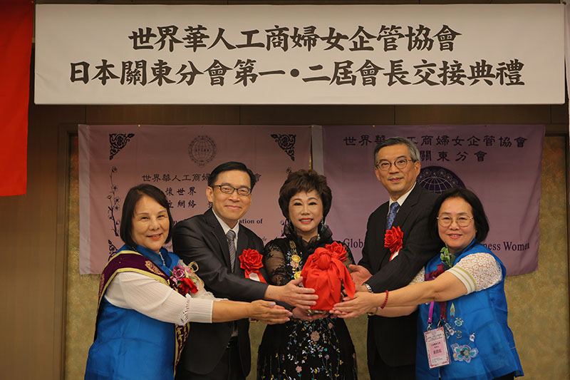 創會會長鄭玉蘭(左1)交接新任會長黃碧霞(右1)。駐日代表處公使周學佑(右2)、橫濱分處處長范振國(左2)，以及世華總會長林淑敏(中)出席見證