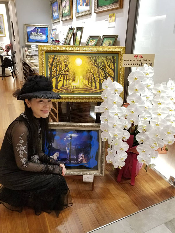 池依依依と日本台湾後援会会長・陳天隆氏、贈呈された花籠とともに記念撮影