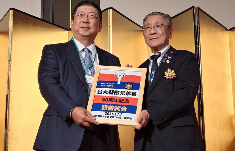 長崎大學醫學部橄欖球隊OB会衞藤正雄會長（右）與台大醫院張志豪副院長(左）交換紀念牌匾